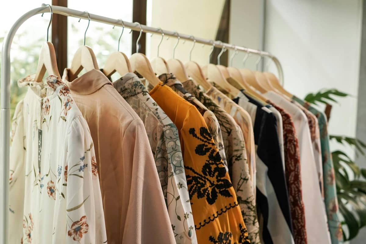 Portant de vêtements féminins élégants aux motifs fleuris dans une boutique lumineuse