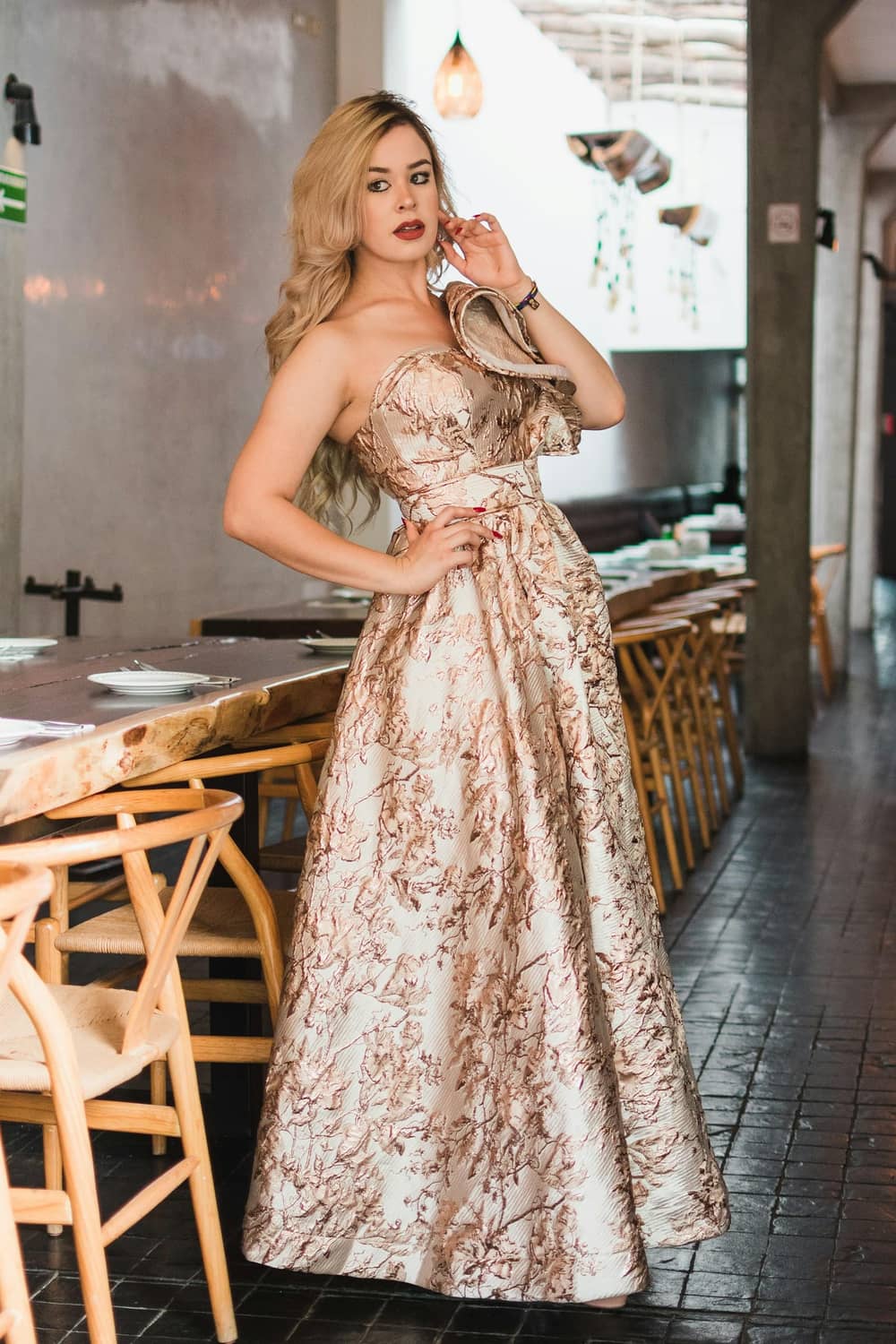 Femme en robe de cérémonie dorée brodée dans un lieu élégant