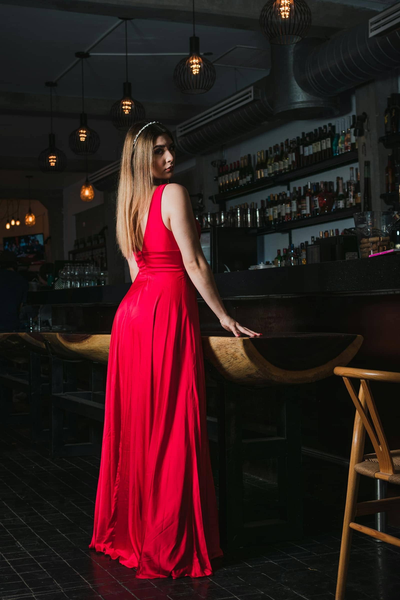 Femme en robe de cocktail rouge élégante dans un bar