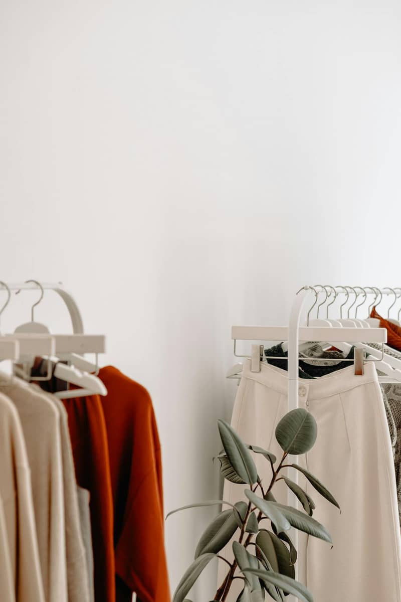 Portant minimaliste avec vêtements aux teintes beige et terracotta