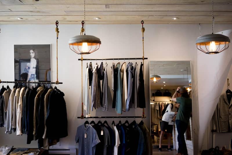 Intérieur de boutique de mode avec portants suspendus et miroir