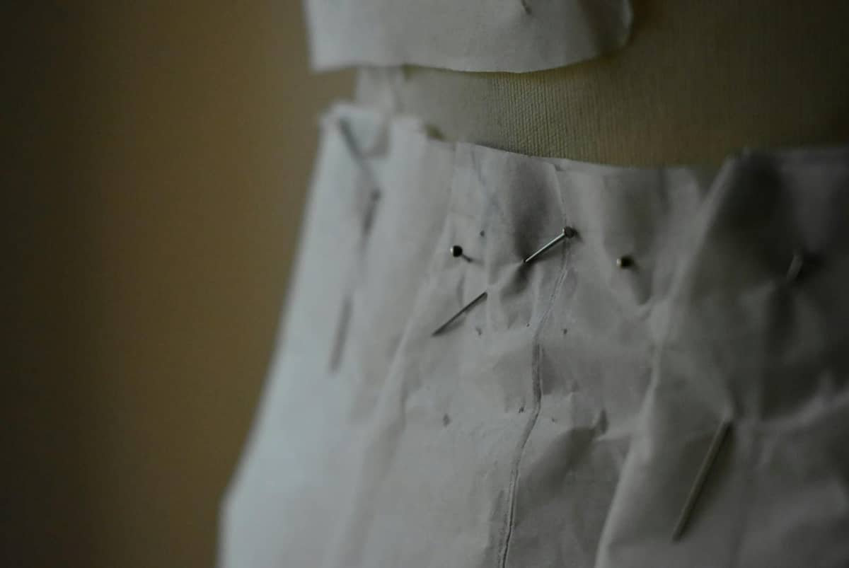 Épingles de couturière sur un patron en tissu, atelier de retouches