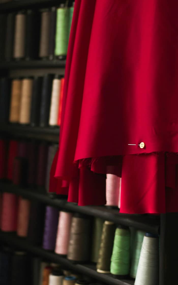 Tissu rouge et bobines de fil colorées en atelier de couture